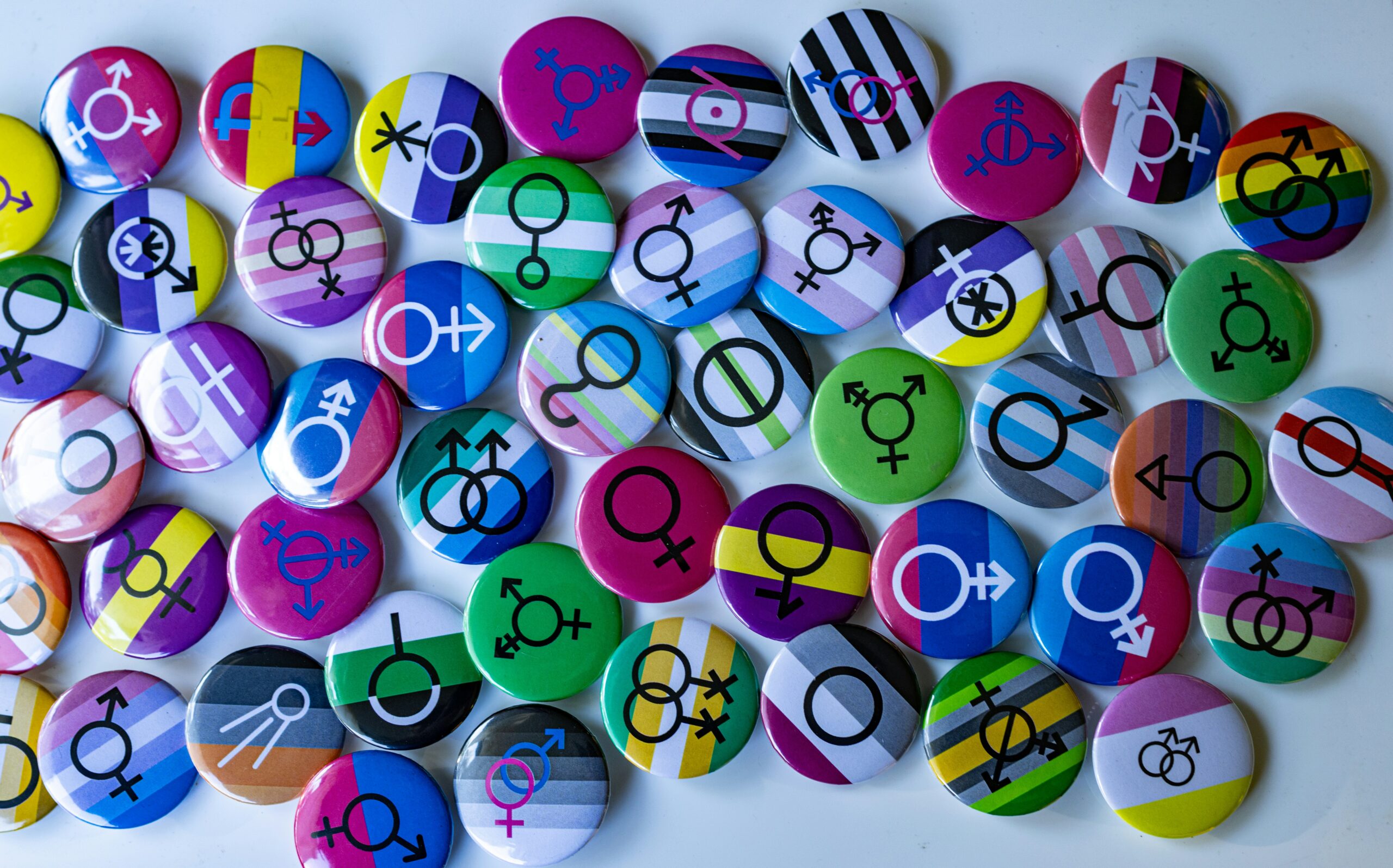 A tray of colourful Pride buttons and badges